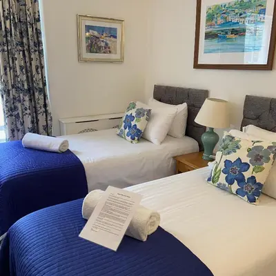 a hotel room with two beds with towels on them at The Slipway B&B in Port Isaac