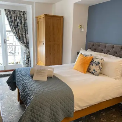 a bedroom with a bed with a book on it at The Slipway B&B in Port Isaac