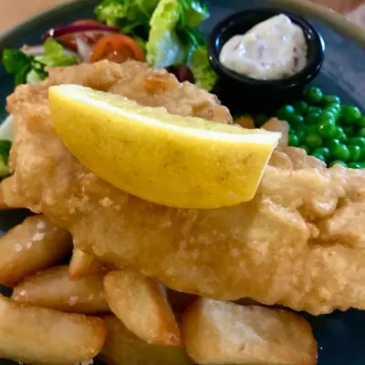 a plate of food with a lemon slice on top at The Slipway B&B in Port Isaac