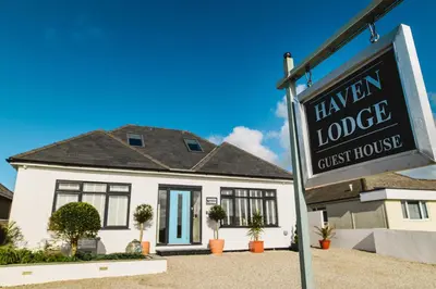a sign in front of a mansion lodge guest house at Haven Lodge Newquay in Newquay