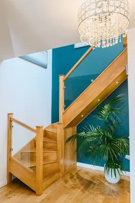 a staircase in a house with a chandelier at Haven Lodge Newquay in Newquay