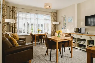 a kitchen and living room with a table and chairs at Haven Lodge Newquay in Newquay