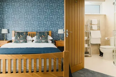 a bedroom with a bed and a bathroom at Haven Lodge Newquay in Newquay