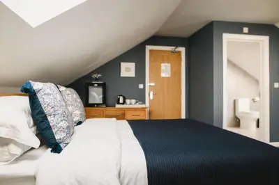 a bedroom with a bed with blue walls at Haven Lodge Newquay in Newquay