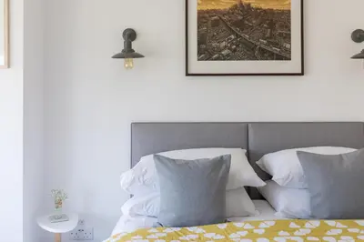 a bed with two pillows and a picture on the wall at Penwyth House in Newquay