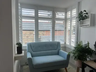 a blue couch in a living room with windows at Penwyth House in Newquay