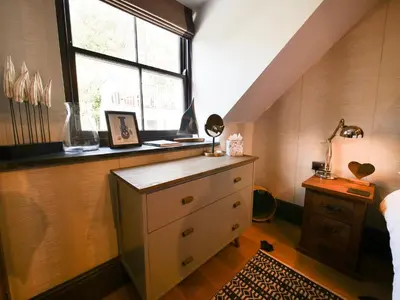 a bedroom with a dresser and a window at Padstow Escapes - Pajar Luxury Penthouse Apartment in Padstow