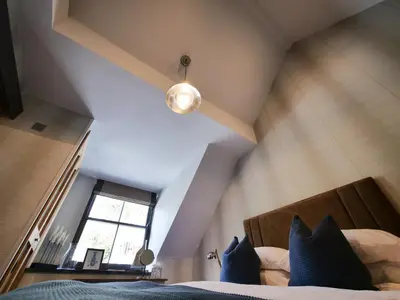 an attic bedroom with a bed and a window at Padstow Escapes - Pajar Luxury Penthouse Apartment in Padstow