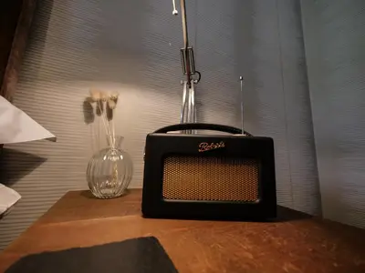 an old radio sitting on a table with a vase at Padstow Escapes - Pajar Luxury Penthouse Apartment in Padstow