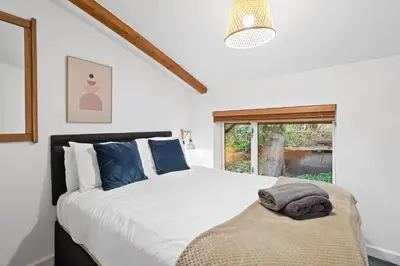 a bedroom with a large bed and a window at Tincroft Cottage - high end, luxury living near the beach in Truro