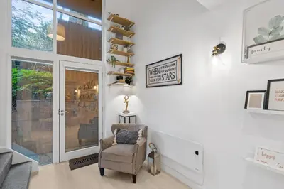 a living room with a chair and a window at Tincroft Cottage - high end, luxury living near the beach in Truro