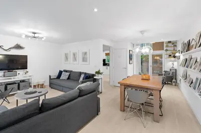 a living room with a couch and a table at Tincroft Cottage - high end, luxury living near the beach in Truro