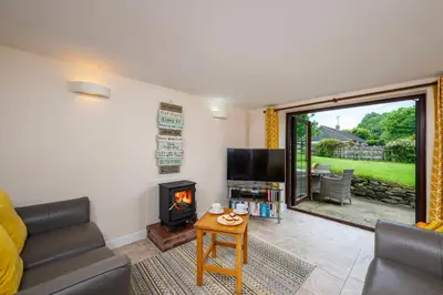 a living room with a couch and a fireplace at Callestock Courtyard Cottages in Truro
