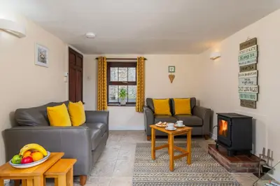 a living room with two couches and a television at Callestock Courtyard Cottages in Truro
