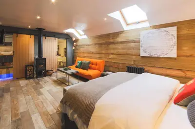 a bedroom with a bed and a couch in a room at An Leti @ Goonwinnow Farm in Newquay