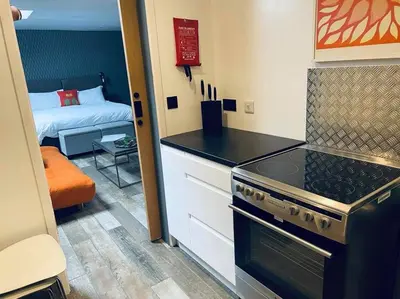 a kitchen with a stove and a room with a bed at An Leti @ Goonwinnow Farm in Newquay