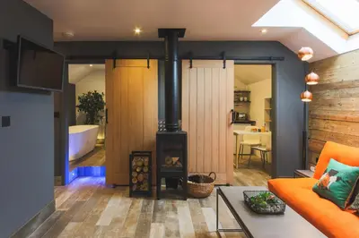 a living room with a fireplace and a bath tub at An Leti @ Goonwinnow Farm in Newquay