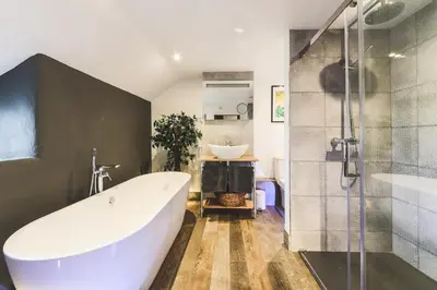 a bathroom with a large tub and a sink at An Leti @ Goonwinnow Farm in Newquay