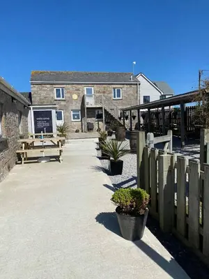 a building with a wooden fence and a patio at Wheal Rose -Beautifully Fitted Lodge Helston Cornwall in Helston
