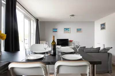 a dining room and living room with a table and chairs at Wheal Rose -Beautifully Fitted Lodge Helston Cornwall in Helston