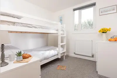 a bedroom with two bunk beds and a window at Wheal Rose -Beautifully Fitted Lodge Helston Cornwall in Helston