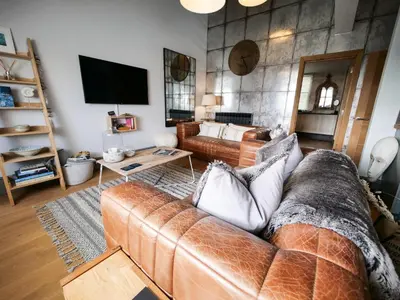 a living room with a couch and a tv at Padstow Escapes - Teyr Luxury Penthouse Apartment in Padstow
