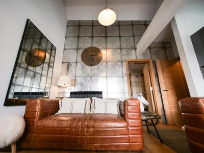 a living room with a brown leather couch at Padstow Escapes - Teyr Luxury Penthouse Apartment in Padstow