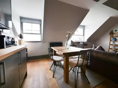 a kitchen and dining room with a table and chairs at Padstow Escapes - Teyr Luxury Penthouse Apartment in Padstow