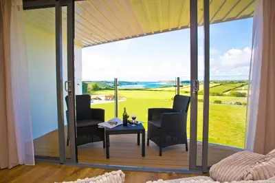 a screened in porch with two chairs and a table at The Pickwick Inn & Oliver's Restaurant in Padstow