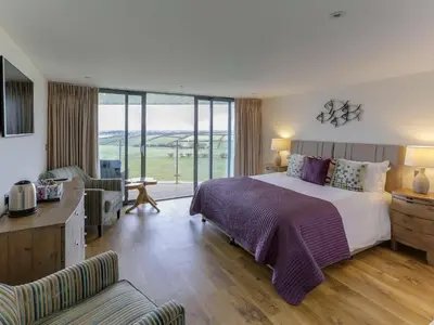 a bedroom with a large bed and a living room at The Pickwick Inn & Oliver's Restaurant in Padstow