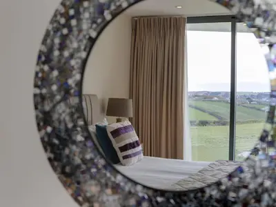 a mirror reflecting a bedroom with a bed and a window at The Pickwick Inn & Oliver's Restaurant in Padstow