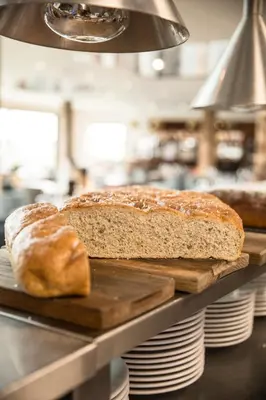 a loaf of bread on a cutting board on a counter at The Pickwick Inn & Oliver's Restaurant in Padstow