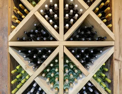 a bunch of wine bottles in a wooden cellar at The Pickwick Inn & Oliver's Restaurant in Padstow