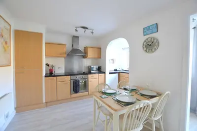 a kitchen with a table and chairs in a room at Beach View Apartments in Porthtowan