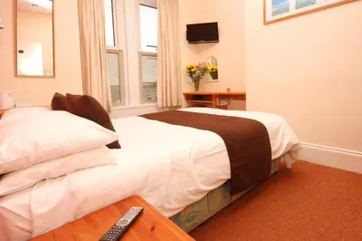 a hotel room with two beds and a television at Surfside Stop in Newquay