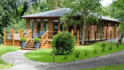 a wooden cabin with a porch and a walk way to it at Chycara House in Truro