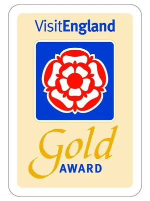 a sign for a gold award with a red flower at Chycara House in Truro