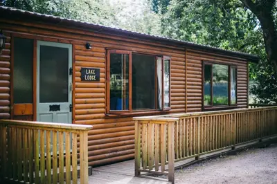 a wooden cabin with a porch and a door at Chycara House in Truro