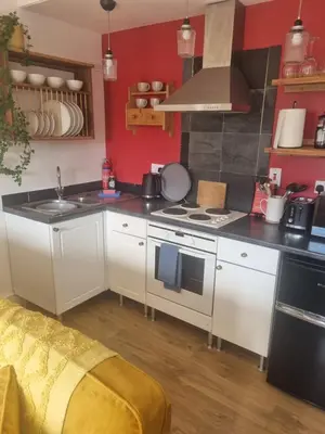 a kitchen with white cabinets and a stove top oven at Halwyn Retreat in St Austell
