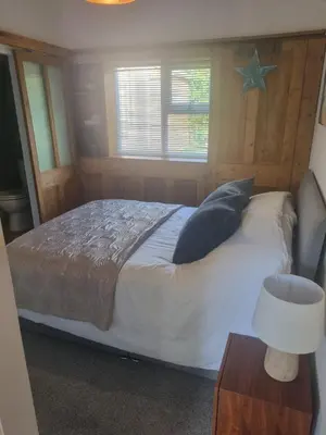 a bedroom with a bed and a star on the wall at Halwyn Retreat in St Austell