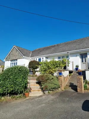 a white house with stairs in front of it at Halwyn Retreat in St Austell
