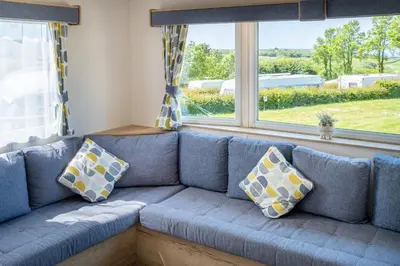 a blue couch in a room with windows at Cornish Coasts Holiday Park in Bude