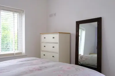 a bedroom with a dresser and a mirror at Cornish Coasts Holiday Park in Bude