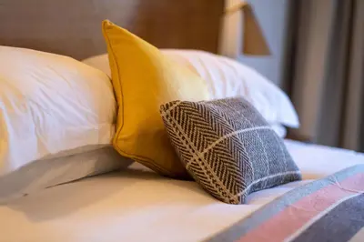 a pillow sitting on top of a bed with pillows at Hotel Meudon in Falmouth