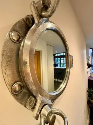 a mirror hanging on a wall with a sink at The Engine House in Truro
