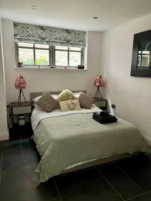 a bedroom with a large bed with two windows at The Engine House in Truro