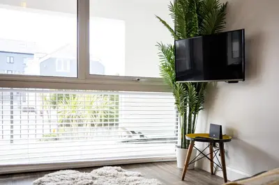 a living room with a tv on a wall next to a window at Westward 14 Polzeath in Polzeath