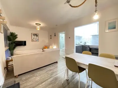 a living room with a couch and a table at Westward 14 Polzeath in Polzeath