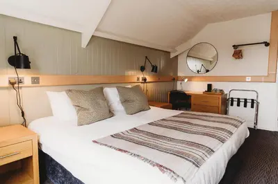 a bedroom with a large white bed and a mirror at Hotel VARA in Truro
