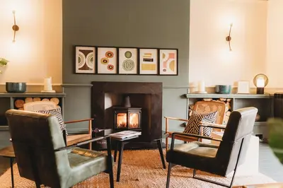 a living room with two chairs and a fireplace at Hotel VARA in Truro